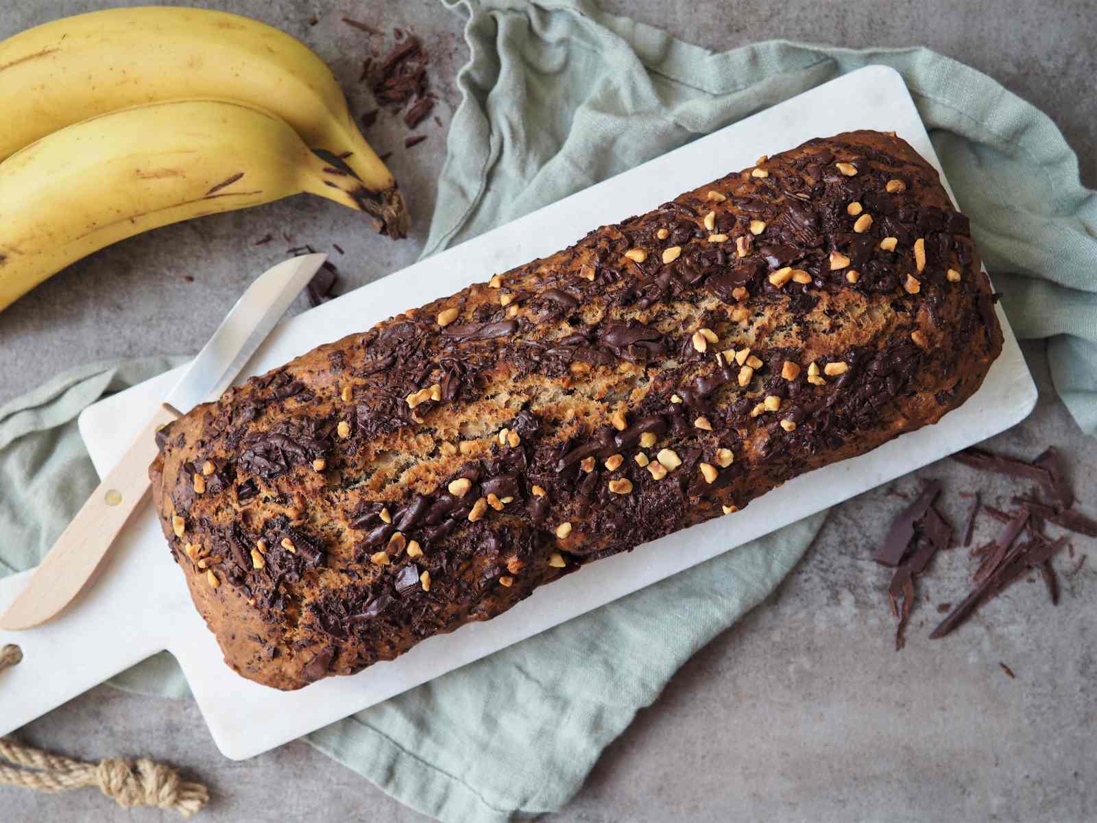 Bananenbrot mit Haselnüssen und Schokolade angerichtet auf Platte