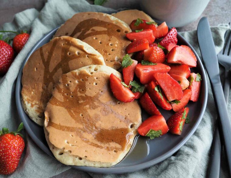 Vegane Pancakes mit Ahornsirup und Erdbeeren